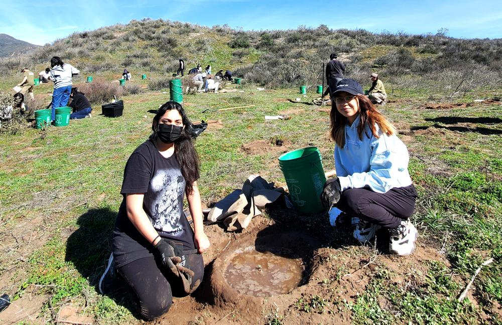 Angie H. and Angie G., 11th grade students at University Prep Value High School planting indigenous species of plants and trees.